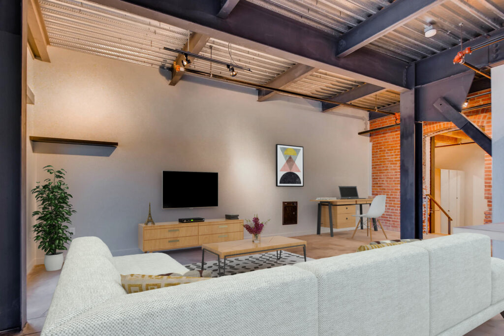 Living room with a couch, TV, wall-art, coffee table and work space