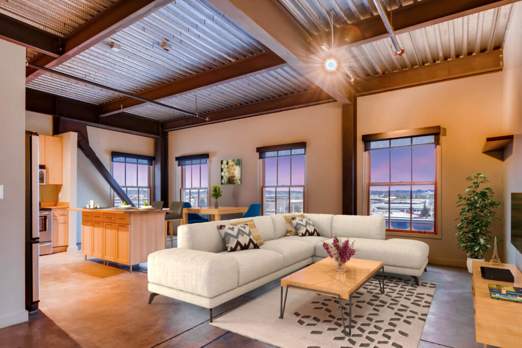 Living room with a couch, TV, dining area and large windows