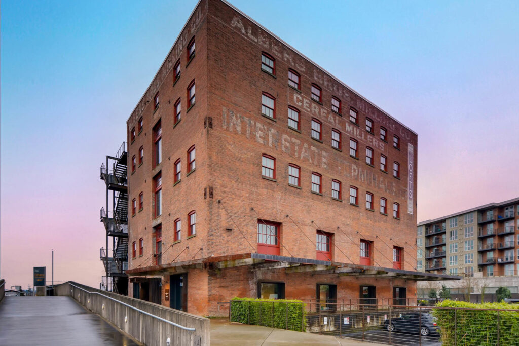 Facade of an old brick building, parking in the back