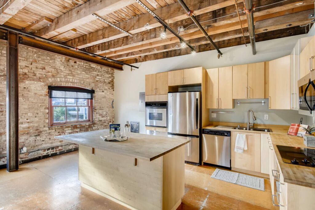 Open kitchen with wooden and glass cabinets, stainless steel appliances, kitchen Island and wooden flooring